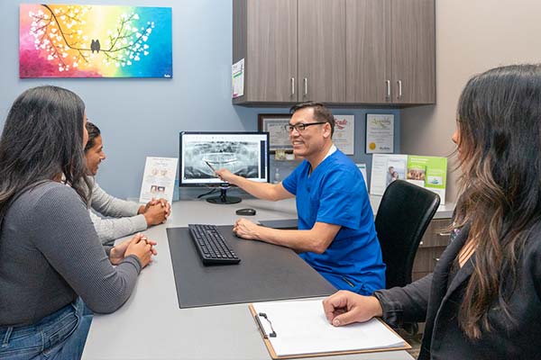 Dr. Le looking at the x-ray with patients at Picasso Dental Care.