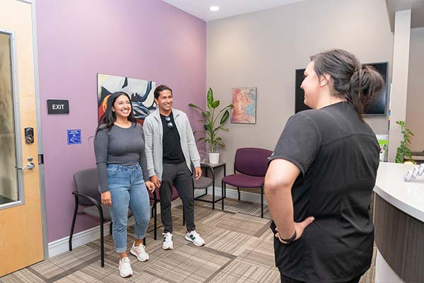 A staff greeting new patients in the reception area.