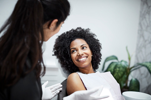 Dentist discussing with smiling female patient at Picasso Dental Care in Temecula, CA